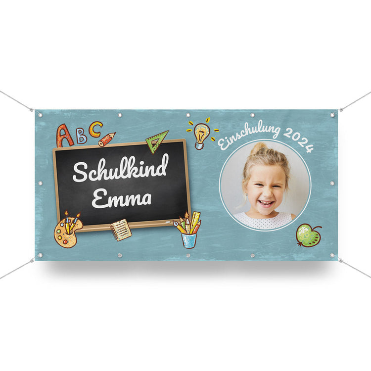 Einschulung Banner "Emma".
Ein selbst personalisierter Banner mit Ösen und Befestigung. Der Banner ist vorgestaltet und kann mit eigenem Namen und Foto gedruckt werden. Hier in blau, mit Comics und dem Satz "Schulkind Emma, Einschulung 2024" als Beispiel.