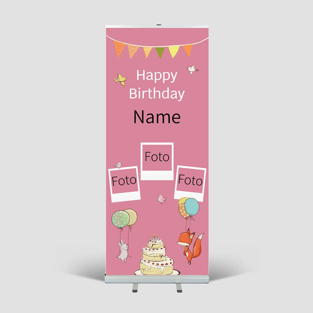 Roll-Up-Aufsteller mit fertigem Druck für Kinder-Geburtstagsfeier mit Name Fotos, und kindlichen Dekoelementen - rosa. Hier in einem weissen Raum, mit sichtbaren Aufstellfüßen und Metallkartusche.