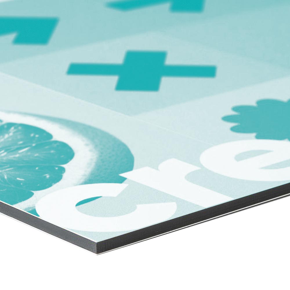 Material Detailbild einer Ecke von einem Alu-Dibond Schild mit einem türkisen Beispieldruck. Die Platte hat einen schwarzen Kern der hier gut gezeigt wird. Der Hintergrund ist weiss.