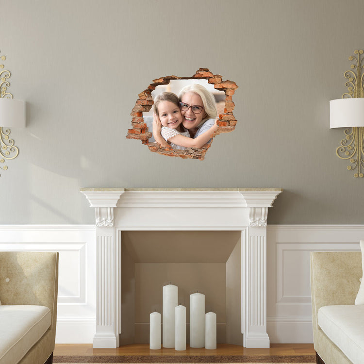 Ein Wanddurchbruch, das aussieht, als ob es durch einen Mauerbruch betrachtet wird, zeigt ein Foto von einer Großmutter und ihrer Enkelin, die sich umarmen und zusammen lächeln. Das Bild ist auf der Wand eines Wohnzimmers über einem Kamin in einem eleganten Raum platziert.