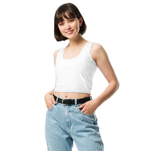 Junge Frau mit kurzen braunen Haaren trägt ein schlichtes weißes Crop-Top, kombiniert mit einer hoch geschnittenen blauen Jeans und einem schwarzen Gürtel. Minimalistischer Look für Casual- und Streetwear-Outfits