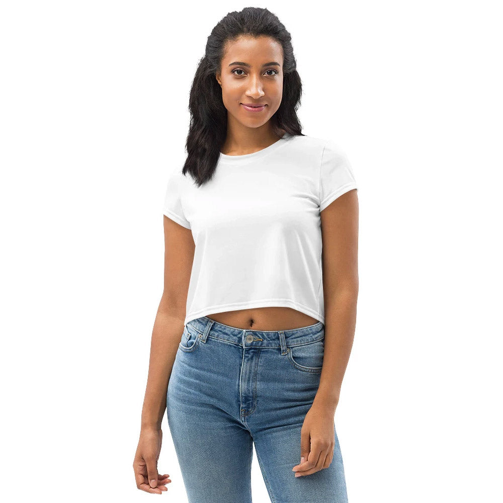 Junge Frau trägt ein schlichtes weißes Crop-T-Shirt mit kurzen Ärmeln, kombiniert mit einer klassischen blauen Jeans. Minimalistischer und vielseitiger Look für Freizeit und Streetwear.