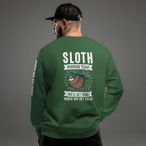 Mann mit schwarzer Cap trägt ein grünes Sweatshirt mit großem Rückendruck: 'Sloth Running Team' und einem entspannten Faultier-Design. Darunter der humorvolle Spruch 'We'll get there when we get there'. Perfekt für gemütliche und lustige Streetwear-Looks.