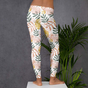 Damen-Leggings mit tropischem Blattmuster in Grün, Beige und Gelb auf weißem Hintergrund. Enganliegend und bequem, ideal für Sport, Yoga oder sommerliche Freizeit-Looks.