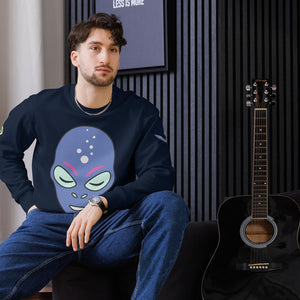 Ein Mann sitzt lässig auf einem schwarzen Sessel und trägt ein dunkelblaues Sweatshirt mit einem auffälligen Alien-Design. Das Motiv zeigt ein futuristisches, blau-lila Alien-Gesicht mit leuchtenden Augen und Blasen auf der Stirn. Der Mann kombiniert das Sweatshirt mit einer Jeans und einer silbernen Uhr. Im Hintergrund steht eine schwarze Akustikgitarre vor einer stilvollen, modernen Wand mit geriffelten Holzpaneelen. Das Sweatshirt ist individuell bedruckbar und perfekt für Sci-Fi-Fans oder Streetwear.