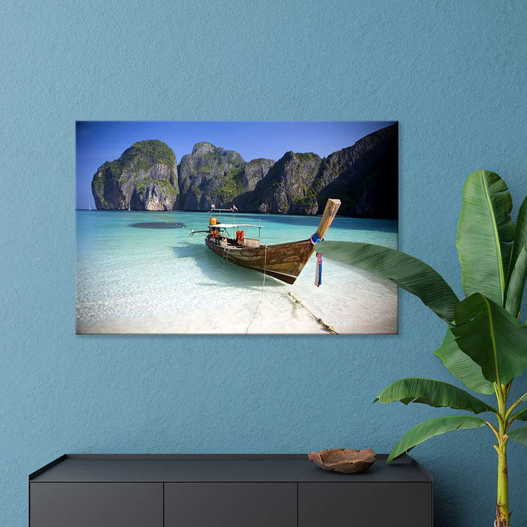 Leinwandbild "Strand mit Boot" an blauer Wand über Sideboard