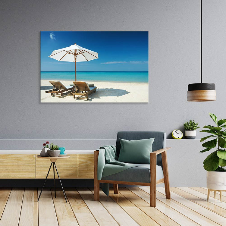 Leinwandbild "Strand mit Liegestühlen" über Sessel im Wohnzimmer